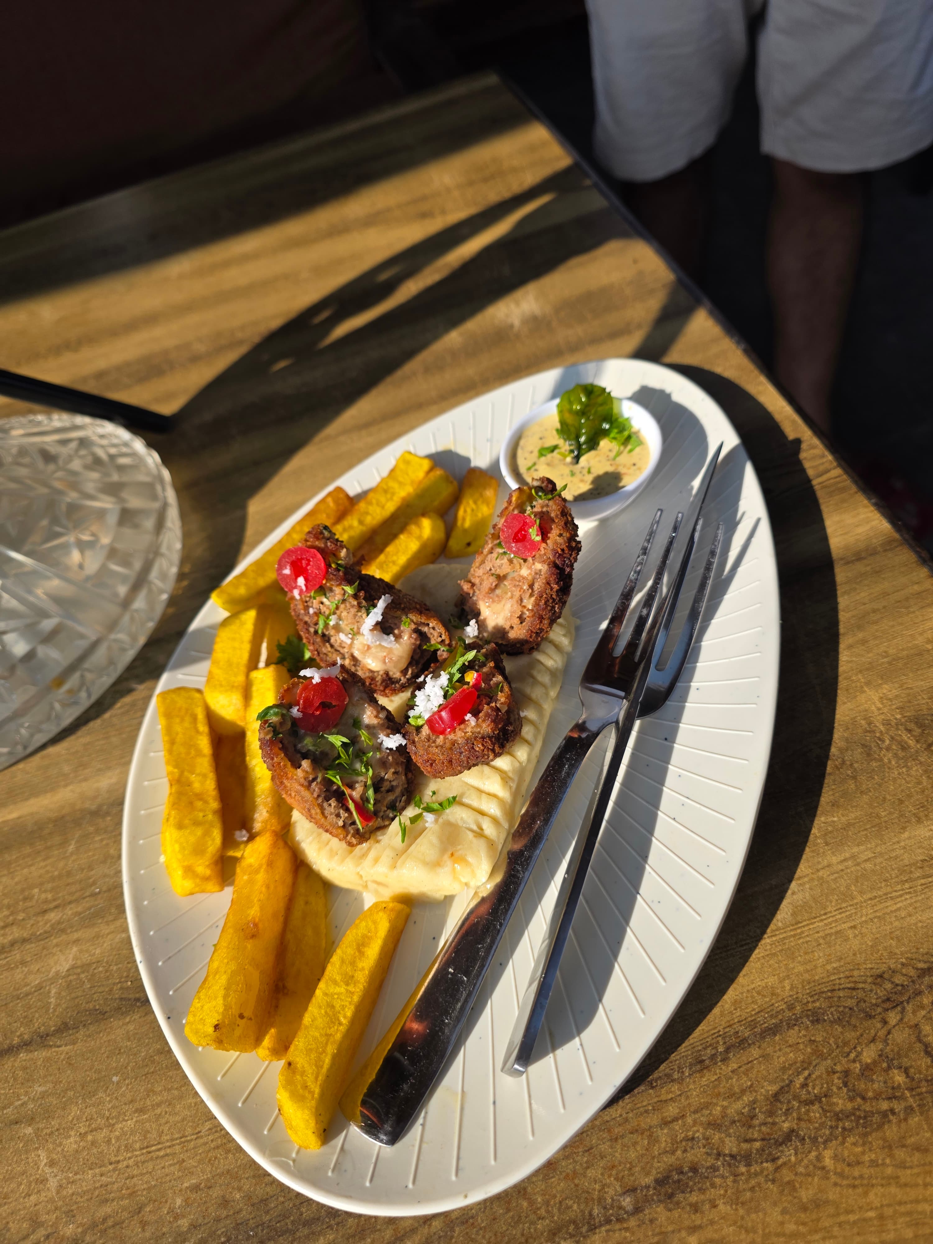Crispy seafood skewers with golden polenta chips and house dipping sauce on a white plate